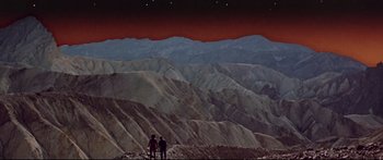 Movie still from “Robinson Crusoe on Mars” (1964), directed by Byron Haskin – Two people standing on top of a hill looking at the sky; Extreme Wide shot, Low angle