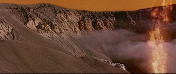Movie still from “Robinson Crusoe on Mars” (1964), directed by Byron Haskin – A mountain with a lot of smoke coming out of it; Extreme Wide shot, High angle