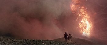 Movie still from “Robinson Crusoe on Mars” (1964), directed by Byron Haskin – Two people are walking on a hill near a cloud of smoke; Extreme Wide shot, Low angle