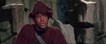 Movie still from “Robinson Crusoe on Mars” (1964), directed by Byron Haskin – A man wearing a hat sitting in front of rocks; Medium shot, High angle