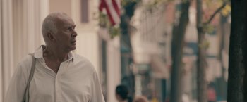 Movie still from “Robot & Frank” (2012), directed by Jake Schreier – A man standing on the sidewalk in front of a building; Close Up shot, Low angle