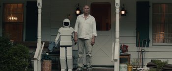 Movie still from “Robot & Frank” (2012), directed by Jake Schreier – A man standing in front of a white robot statue; Wide shot, Low angle