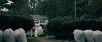 Movie still from “Robot & Frank” (2012), directed by Jake Schreier – A person in a costume walking in front of a house; Extreme Wide shot, Low angle