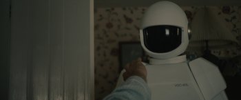 Movie still from “Robot & Frank” (2012), directed by Jake Schreier – A person holding a remote control in front of a television; Medium shot, Over the shoulder angle