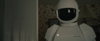 Movie still from “Robot & Frank” (2012), directed by Jake Schreier – A white robot standing next to a wall; Medium shot, Over the shoulder angle