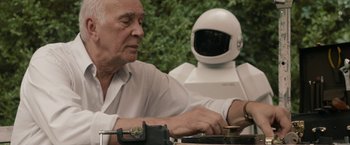 Movie still from “Robot & Frank” (2012), directed by Jake Schreier – An old man and a robot working on a computer; Medium shot, Low angle