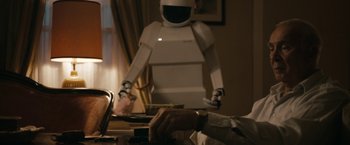 Movie still from “Robot & Frank” (2012), directed by Jake Schreier – A person is standing in front of a robot; Medium shot, Over the shoulder angle