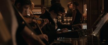 Movie still from “Robot & Frank” (2012), directed by Jake Schreier – A man sitting at a table with a violin and a laptop; Medium shot, Over the shoulder angle