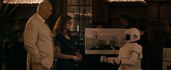Movie still from “Robot & Frank” (2012), directed by Jake Schreier – A woman standing next to a man holding a wine glass; Medium shot, Over the shoulder angle