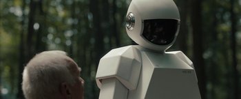 Movie still from “Robot & Frank” (2012), directed by Jake Schreier – A person is standing next to a white robot; Close Up shot, Over the shoulder angle