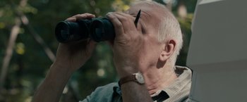 Movie still from “Robot & Frank” (2012), directed by Jake Schreier – An older man looking through a pair of binoculars; Close Up shot, Low angle