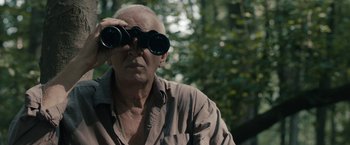 Movie still from “Robot & Frank” (2012), directed by Jake Schreier – An older man looking through a pair of binoculars; Close Up shot, Low angle
