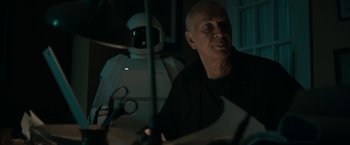 Movie still from “Robot & Frank” (2012), directed by Jake Schreier – An older man sitting in front of a robot; Medium shot, Over the shoulder angle