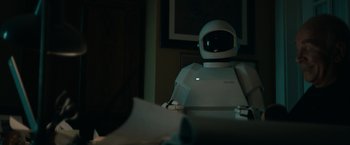 Movie still from “Robot & Frank” (2012), directed by Jake Schreier – A robot sitting in front of a computer monitor; Medium shot, High angle