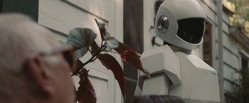 Movie still from “Robot & Frank” (2012), directed by Jake Schreier – A robot is standing next to a plant; Close Up shot, Over the shoulder angle
