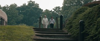 Movie still from “Robot & Frank” (2012), directed by Jake Schreier – Two men are standing on some steps in the woods; Wide shot, Low angle