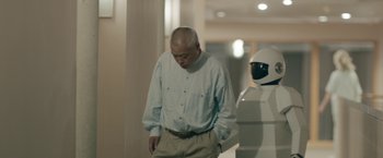 Movie still from “Robot & Frank” (2012), directed by Jake Schreier – An older man standing next to a white robot; Medium shot, Over the shoulder angle