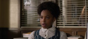 Movie still from “13 Reasons Why” (2017), created by Brian Yorkey – A woman with a very large afro is looking at the camera; Close Up shot, Over the shoulder angle