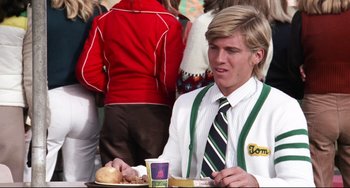 Movie still from “Rock 'n' Roll High School” (1979), directed by Joe Dante – A man in a white shirt and tie eating a sandwich; Medium shot, Over the shoulder angle