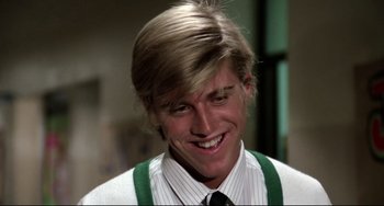 Movie still from “Rock 'n' Roll High School” (1979), directed by Joe Dante – A man with blonde hair wearing a green tie; Close Up shot, Low angle