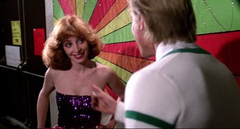 Movie still from “Rock 'n' Roll High School” (1979), directed by Joe Dante – A man and a woman are talking in front of a colorful umbrella; Medium shot, Over the shoulder angle