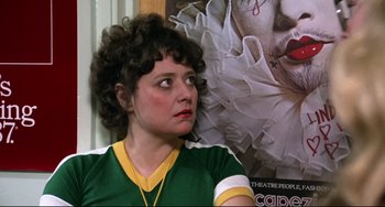 Movie still from “Rock 'n' Roll High School” (1979), directed by Joe Dante – A woman sitting in front of a poster of a movie; Close Up shot, Over the shoulder angle