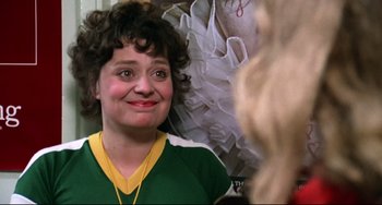 Movie still from “Rock 'n' Roll High School” (1979), directed by Joe Dante – A woman in a green and yellow shirt looking at the camera; Close Up shot, Over the shoulder angle