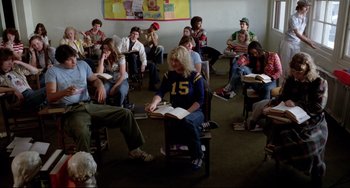 Movie still from “Rock 'n' Roll High School” (1979), directed by Joe Dante – A group of people sitting in a room with books; Wide shot, High angle