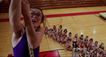 Movie still from “Rock 'n' Roll High School” (1979), directed by Joe Dante – A woman climbing a rope in front of a group of kids; Wide shot, Overhead angle