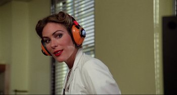 Movie still from “Rock 'n' Roll High School” (1979), directed by Joe Dante – A woman wearing ear muffs while standing in front of a window; Close Up shot, Low angle