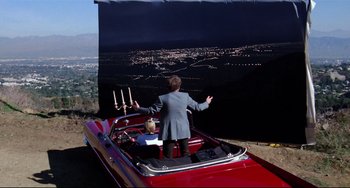 Movie still from “Rock 'n' Roll High School” (1979), directed by Joe Dante – A man standing in the back of a red boat; Extreme Wide shot, High angle