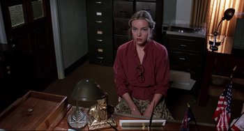 Movie still from “Rock 'n' Roll High School” (1979), directed by Joe Dante – A woman sitting at a desk in front of a laptop computer; Medium shot, High angle