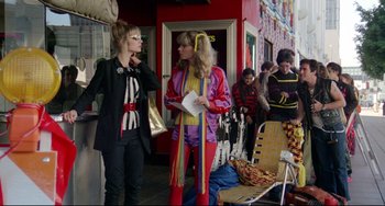 Movie still from “Rock 'n' Roll High School” (1979), directed by Joe Dante – Two women standing on the sidewalk talking to each other; Medium shot, Low angle
