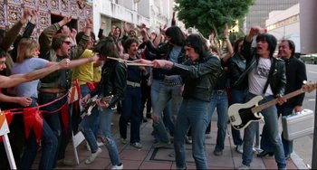 Movie still from “Rock 'n' Roll High School” (1979), directed by Joe Dante – A group of young people dancing on the sidewalk; Wide shot, High angle
