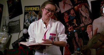 Movie still from “Rock 'n' Roll High School” (1979), directed by Joe Dante – A woman is holding a book in her hands; Medium shot, Low angle
