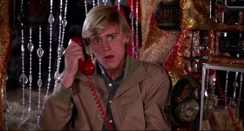Movie still from “Rock 'n' Roll High School” (1979), directed by Joe Dante – A young man holding a red phone up to his ear; Close Up shot, Low angle