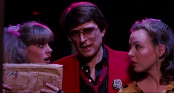 Movie still from “Rock 'n' Roll High School” (1979), directed by Joe Dante – A group of people standing around a man wearing a red jacket; Close Up shot, Low angle