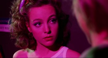 Movie still from “Rock 'n' Roll High School” (1979), directed by Joe Dante – A young woman with blue eyes and a pink light; Close Up shot, Over the shoulder angle