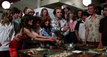 Movie still from “Rock 'n' Roll High School” (1979), directed by Joe Dante – A group of people standing in a kitchen preparing food; Medium shot, High angle