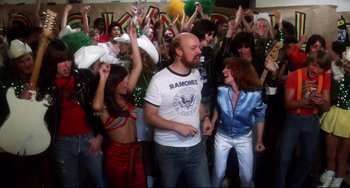 Movie still from “Rock 'n' Roll High School” (1979), directed by Joe Dante – A group of people in a room with arms in the air; Medium shot, High angle