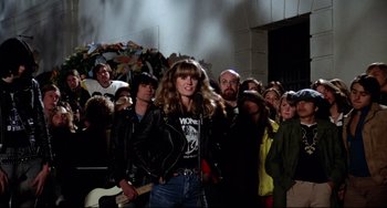 Movie still from “Rock 'n' Roll High School” (1979), directed by Joe Dante – A group of people standing in front of a building; Medium shot, Low angle