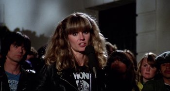 Movie still from “Rock 'n' Roll High School” (1979), directed by Joe Dante – A woman in a leather jacket is holding a microphone; Close Up shot, Low angle