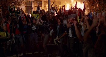 Movie still from “Rock 'n' Roll High School” (1979), directed by Joe Dante – A group of people standing in front of a building; Wide shot, High angle
