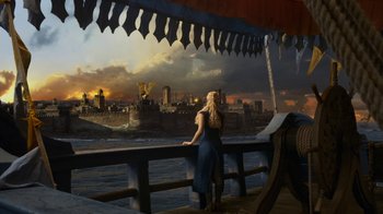 Movie still from “Game of Thrones” (2011), created by D.B. Weiss – A woman standing on a pier looking out over a city; Extreme Wide shot, Over the shoulder angle