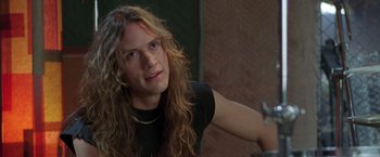 Movie still from “Rock Star” (2001), directed by Stephen Herek – A person with long curly hair; Close Up shot, Over the shoulder angle