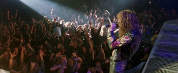 Movie still from “Rock Star” (2001), directed by Stephen Herek – A group of people in a crowd at an event; Wide shot, High angle