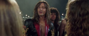 Movie still from “Rock Star” (2001), directed by Stephen Herek – A man with long brown hair wearing a leather jacket; Close Up shot, Low angle
