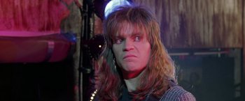 Movie still from “Rock Star” (2001), directed by Stephen Herek – A man with long hair is looking at the camera; Close Up shot, Over the shoulder angle