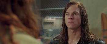 Movie still from “Rock Star” (2001), directed by Stephen Herek – A man with long brown hair wearing a leather jacket; Close Up shot, Over the shoulder angle