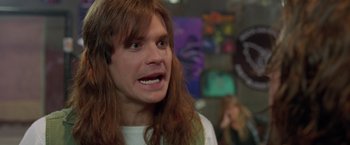 Movie still from “Rock Star” (2001), directed by Stephen Herek – A man with long hair is looking at the camera; Close Up shot, High angle